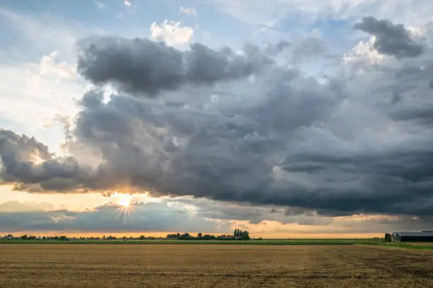 Photo of Sun tries to break through storm clouds over the countryside of Holland