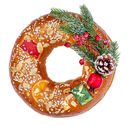 Christmas fruit cake decorated with fir tree branch, glazed fruits  and nuts isolated on white background.  Roscon de reyes Top view