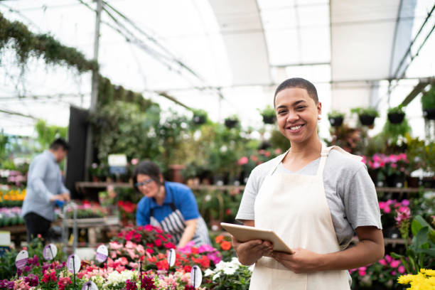 portrait of florist using tablet at small business flower shop - flower computer young women selling imagens e fotografias de stock