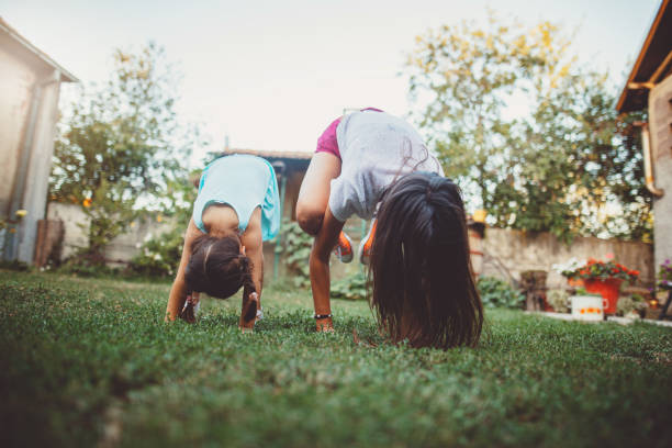 maman et descendant faisant le yoga à l'extérieur - inversion yoga photos et images de collection