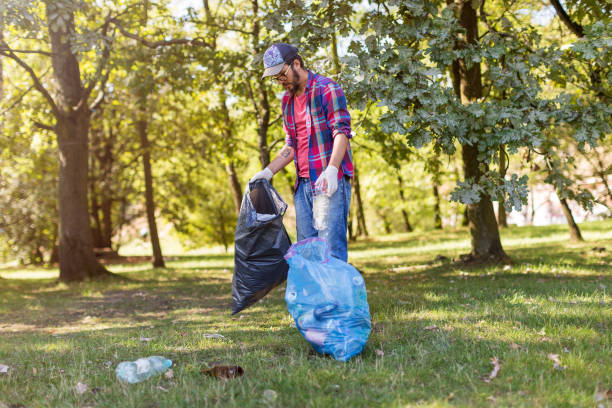 istock Young man picking up litter in his local park 1172961044