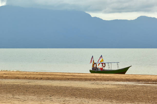 Boat on the beach at Bako National Park stock photo
