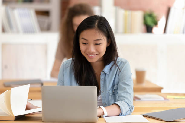 istock Smiling Asian female student studying, using laptop in classroom 1172962652