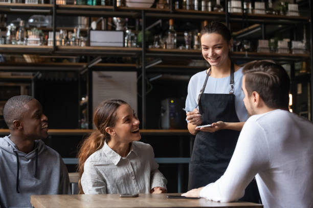 istock Diverse friends sitting in restaurant placing order talking with waitress 1172964156