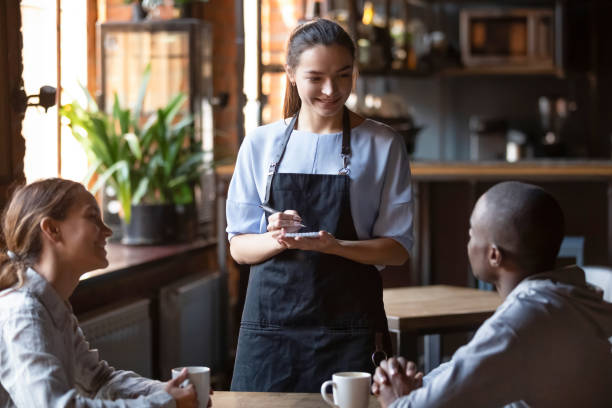 istock Waitress welcoming restaurant guests take order writing on notepad 1172964157