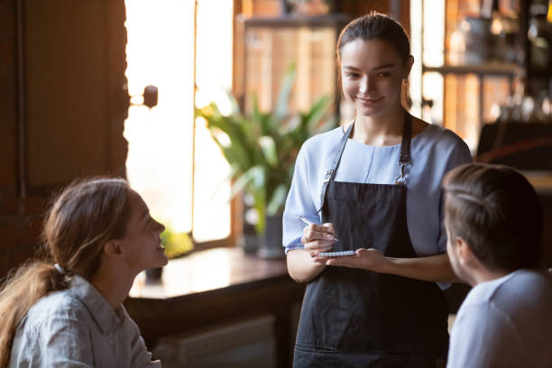 istock Smiling waitress serving a married couple take order 1172964178
