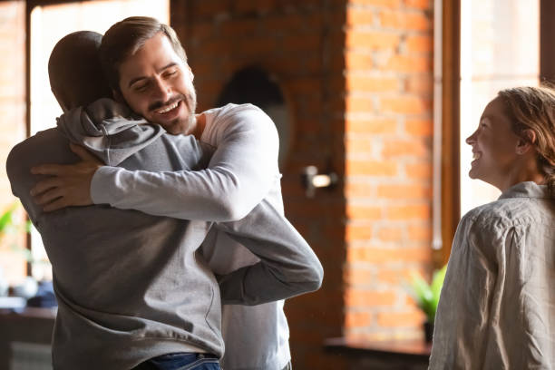 istock Guys meet in cafe glad to see each other embracing 1172964181