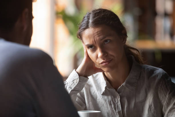 Bored woman sitting on speed dating with boring male Focus on mixed race irritated young female sitting in cafeteria on speed dating with boring male rear view. Unsuccessful unlucky romantic date failure, bad first impression and poor companion concept nasty couple stock pictures, royalty-free photos & images