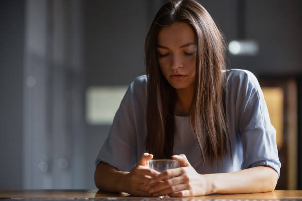 pensive young woman sitting on bar counter drink alcohol - alcohol alcoholism addiction drinking imagens e fotografias de stock