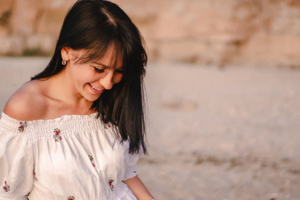 istock beautiful young brunete woman's hair develop in the wind on the beach. the model wearing boho style clothes, girl enjoys freedoom and sunrise 1172966394