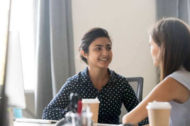 istock Female coworkers talk near computer discussing project 1172966454