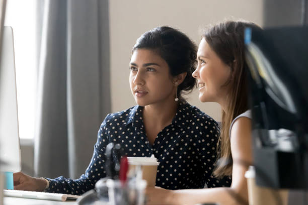 istock Multiracial girls work on computer in office together 1172966463