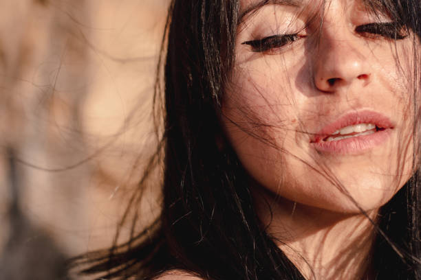 istock beautiful young brunete woman's hair develop in the wind on the beach. the model wearing boho style clothes, girl enjoys freedoom and sunrise 1172966574