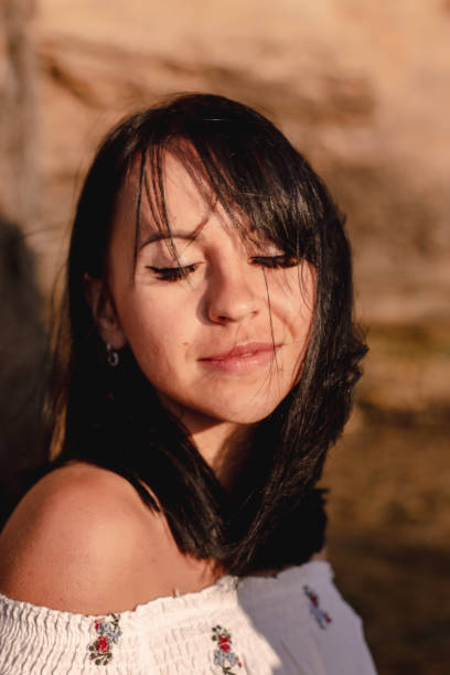 istock beautiful young brunete woman's hair develop in the wind on the beach. the model wearing boho style clothes, girl enjoys freedoom and sunrise 1172967652