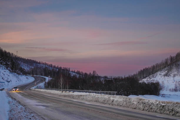 el camino en las montañas. atardecer rosa. la cubierta de nieve en la carretera en las montañas. serpentina en las montañas. coches que conducen por una carretera sinuosa en las montañas de altai - road winding road mountain spiral staircase fotografías e imágenes de stock