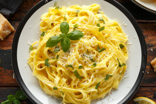 istock Pasta al Limone, Lemon with basil and parmesan cheese on wooden table 1172970606