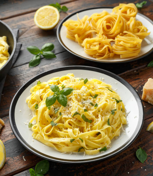 istock Pasta al Limone, Lemon with basil and parmesan cheese on wooden table 1172970644