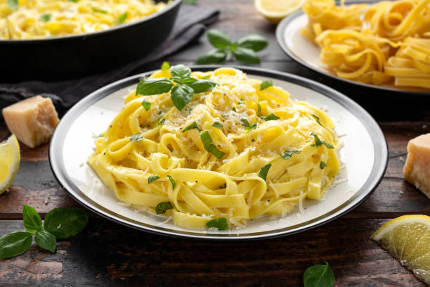 istock Pasta al Limone, Lemon with basil and parmesan cheese on wooden table 1172970698