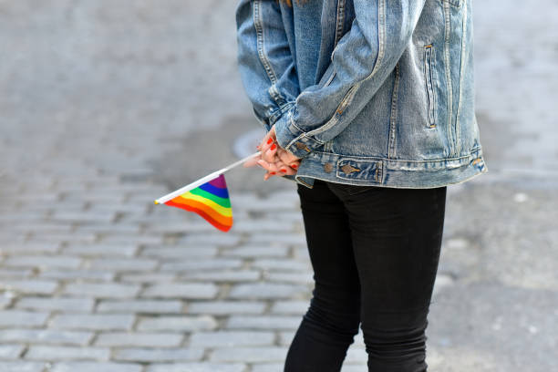 istock Woman in Street Holding Pride Flag 1172971237