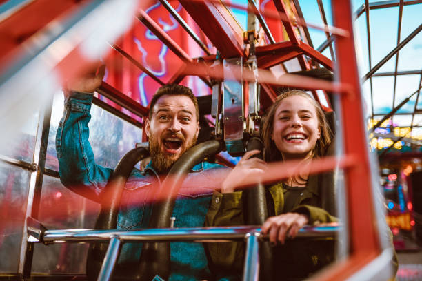 テーマパークでジェットコースターに乗って興奮した女性と怖い男性 - rollercoaster carnival amusement park ride screaming ストックフォトと画像
