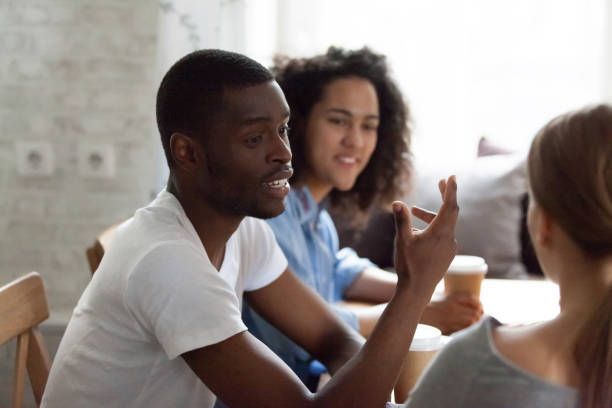 istock Happy african american guy talking to friends. 1172977549