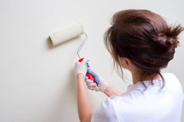 istock girl paints the wall paint roller 1172977941