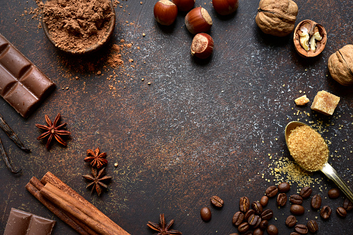 Culinary background with ingredients for baking chocolate cookies or cake on a dark brown slate, stone or concrete background. Top view with copy space.