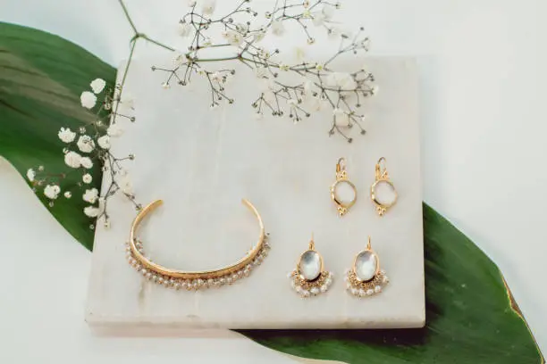 A bracelet and two pairs of earrings beautifully set on a white marble piece