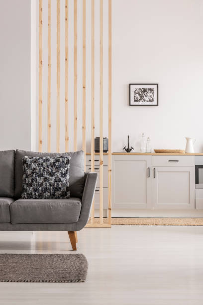 istock Open plan living room and kitchen interior with white cupboards and grey sofa with pillows 1172982192