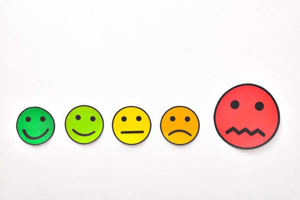istock Paper face cutouts on white table highlighting negative rating 1172984467