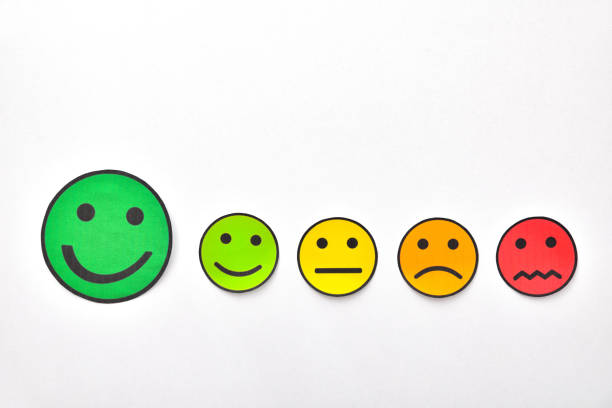 istock Paper face cutouts on white table highlighting positive rating 1172984468