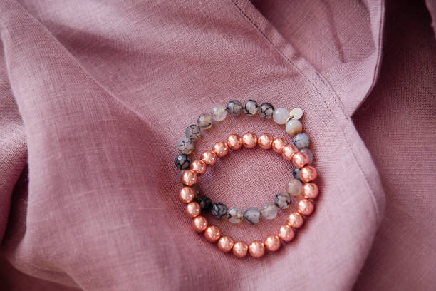 istock Rose gold stone bracelets on a pastel linen fabric 1172989798