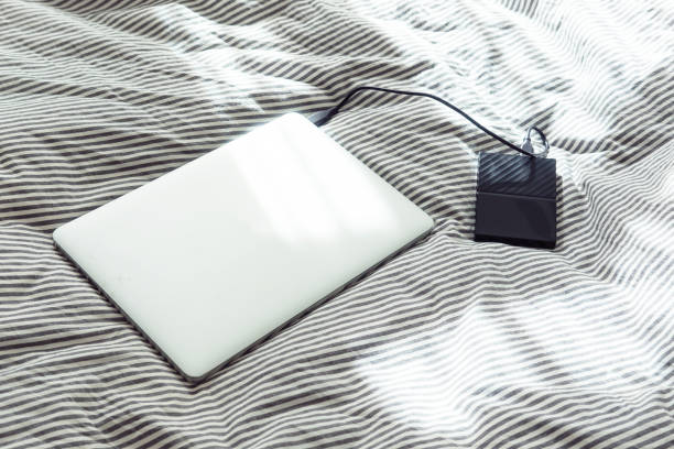 istock Laptop with a hard drive on a bed 1172991639