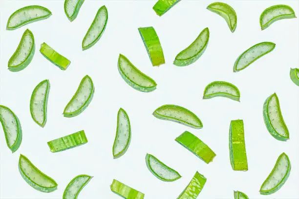 Slices of fresh green aloe vera on white isolated background.Flat lay.Top view.