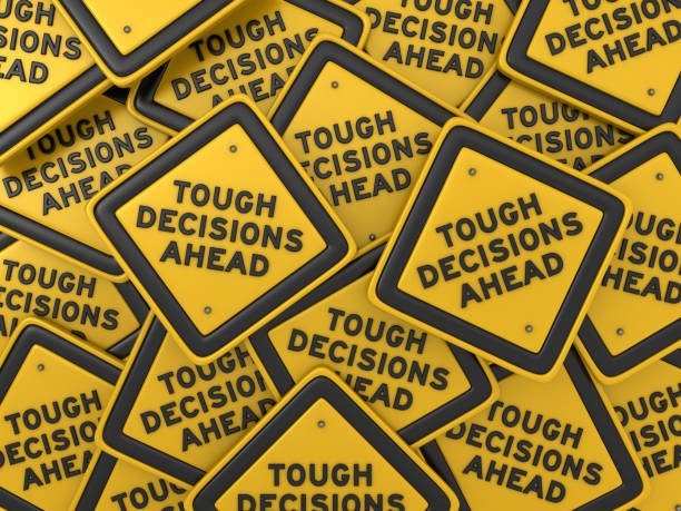 istock TOUGH DECISIONS AHEAD Road Sign - 3D Rendering 1172996936