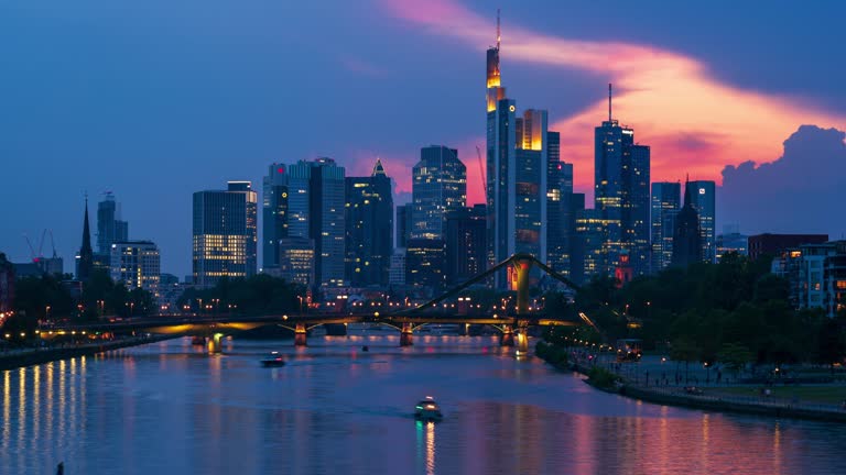 Frankfurt am Main skyline , Floberbrucke bridge, and River Main, dusk to night 4k time lapse