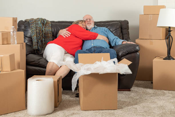 istock Affectionate Tired Senior Adult Couple Resting on Couch Surrounded By Moving Boxes 1173000214