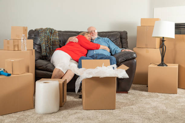 istock Affectionate Tired Senior Adult Couple Resting on Couch Surrounded By Moving Boxes 1173001246