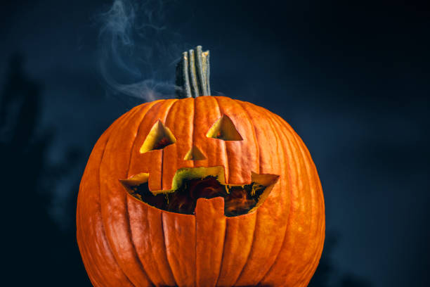 Lights Out Jack o' Lantern A creepy jack o' lantern out doors whose candle just blew out. jack o lantern photos stock pictures, royalty-free photos & images