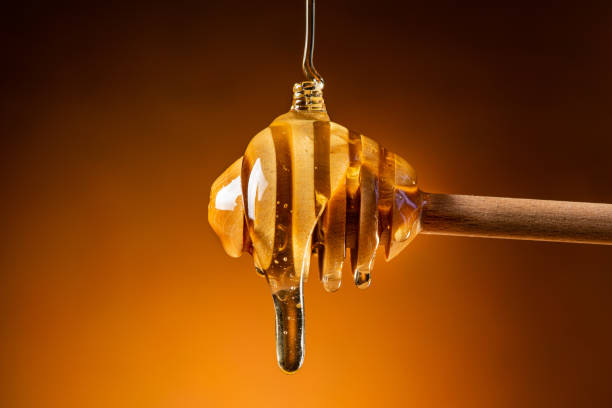 istock acacia honey flows from the ladle in the foreground 1173009062
