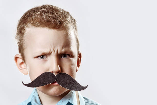 istock Serious boy with a large moustache frowned against the gray background 1173009073
