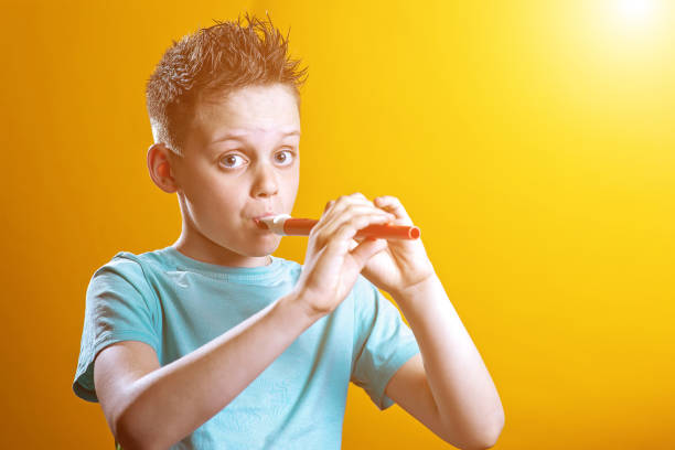 istock a boy in a light t-shirt playing on a pipe on a colored background 1173009764
