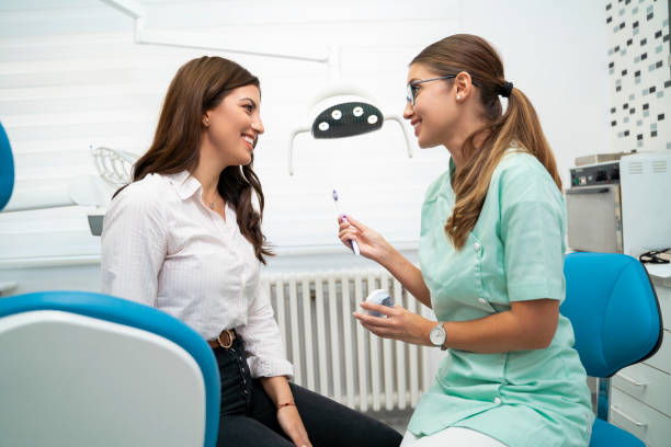 istock Dentist holding toothbrush and teeth model and talking 1173011124