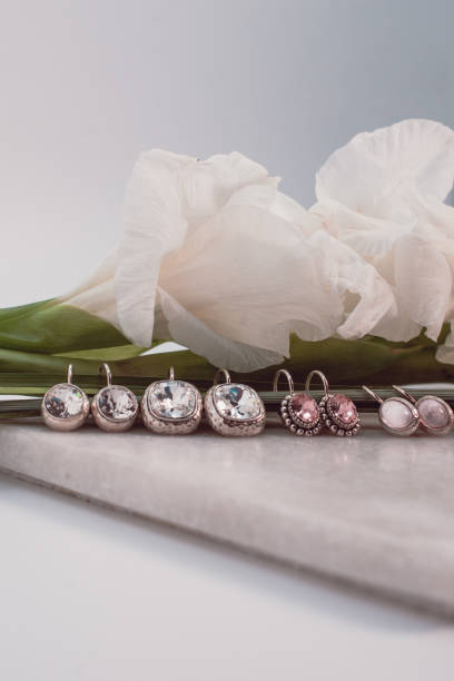 istock Closeup on Earrings and white roses in a white background 1173014515