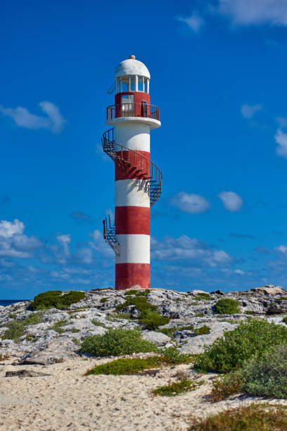 istock Lighthouse on a rocky shore in Cancun. Clear sky and blue sea. Mexico. 1173017358