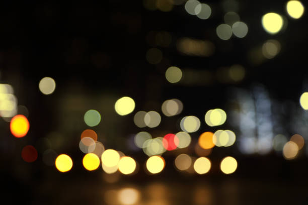 Abstract bokeh background of night street with car and street lamps. City life, defocused lights from cityscape, style color tone. Concept of abstract stylish urban backgrounds for design. Copy space