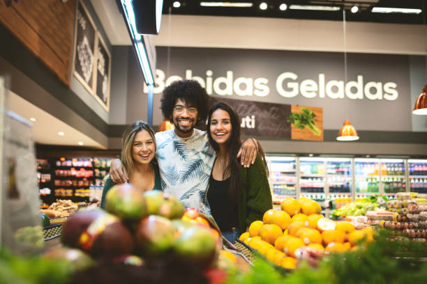 group of friends shopping in a grocery and looking at camera - reduction looking at camera finance business imagens e fotografias de stock