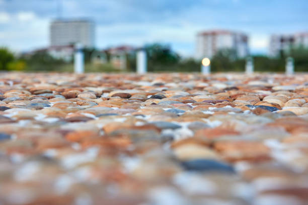 istock Bridge paved with sea pebbles orange color close-up. 1173022596