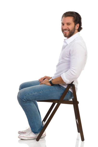 istock Handsome Smiling Man Is Sitting On A Chair. Side View. 1173024823