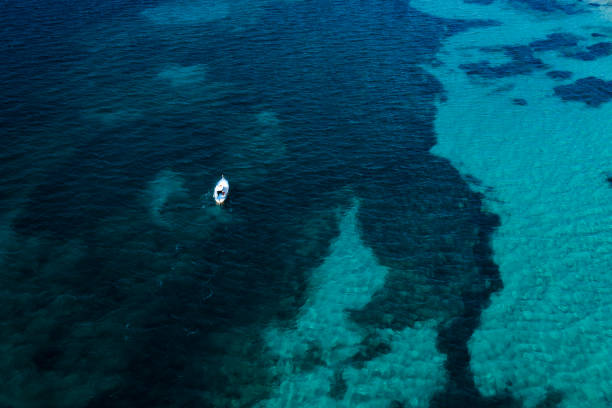 вид сверху, потрясающий вид с воздуха на красивую рыбацкую лодку с рыбаком на борту, плывущих по синему морю. побережье амальфи, италия - 5954 стоковые фото и изображения